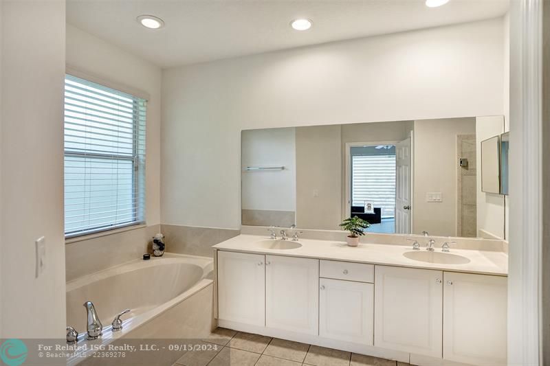 The master bathroom features a bathtub, double sinks, a shower, and a separate toilet area.