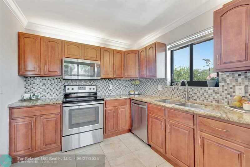 Tiled backsplash, wood cabinetry with built in lighting