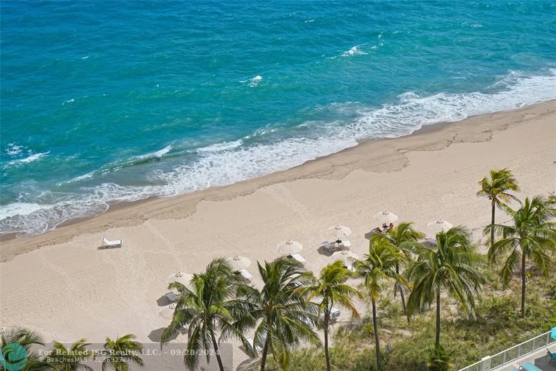 Looking down from the balcony to our beautiful beach. Chairs and umbrellas are available for owners.