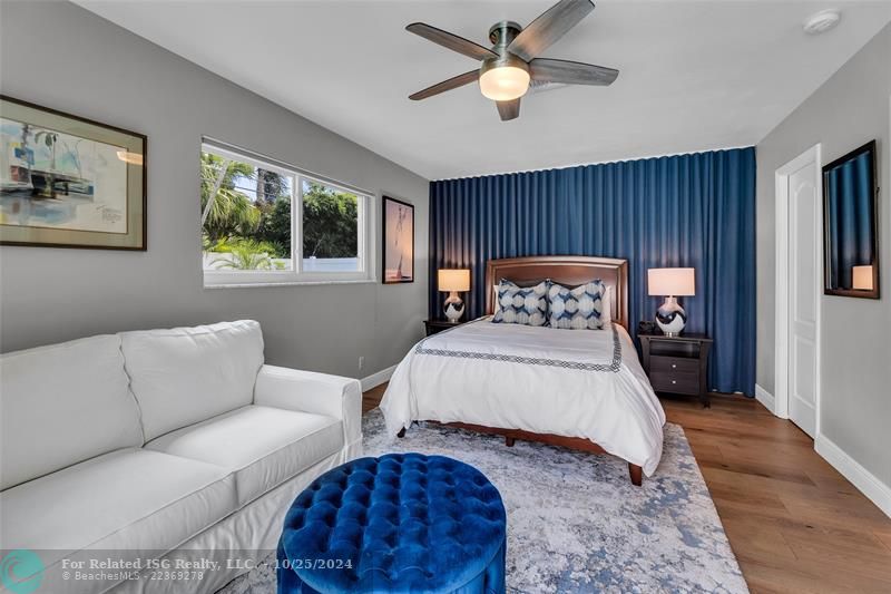 This bedroom perfectly accommodates a Queen bed as well as this Love seat area.