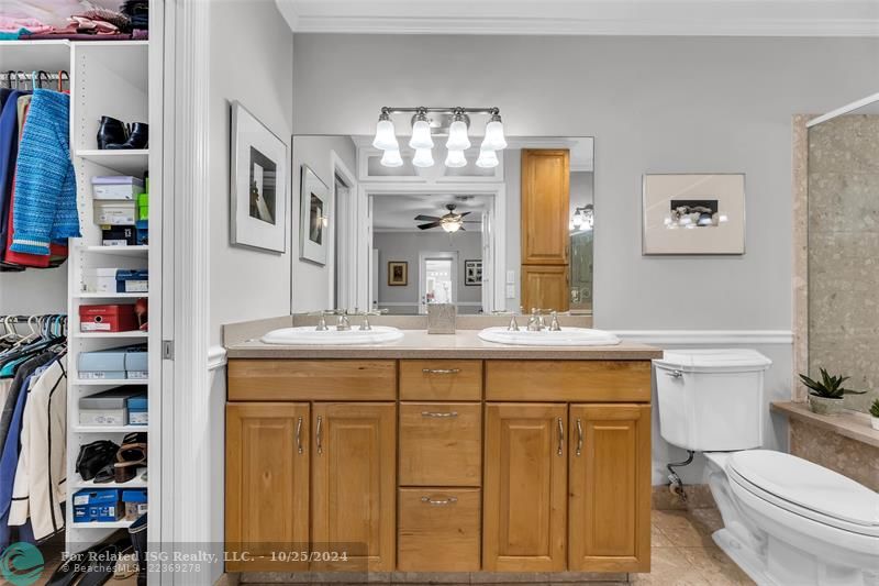 Just a little peek into the L shaped closet with loads of storage, with a pocket door separating it from this comfortable bathroom.