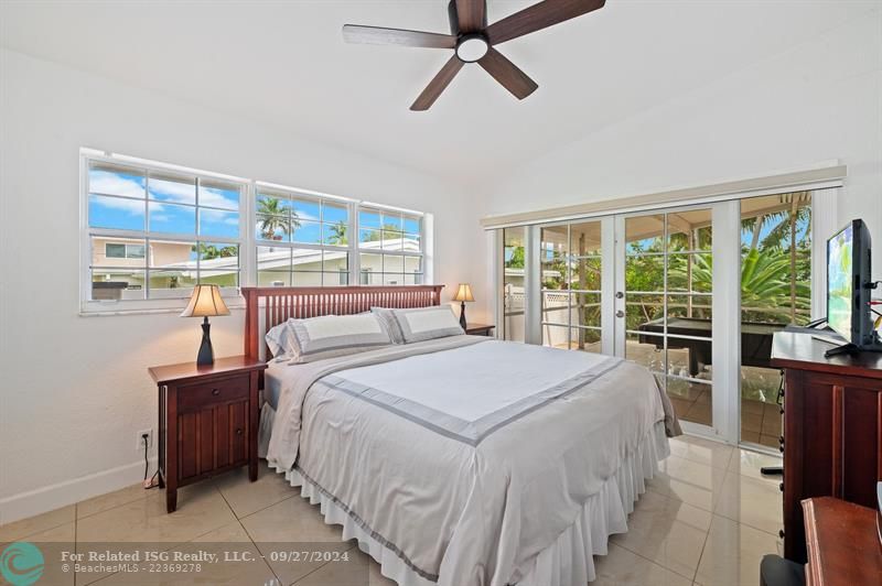 Primary Bedroom with double doors out to the covered and screened patio.