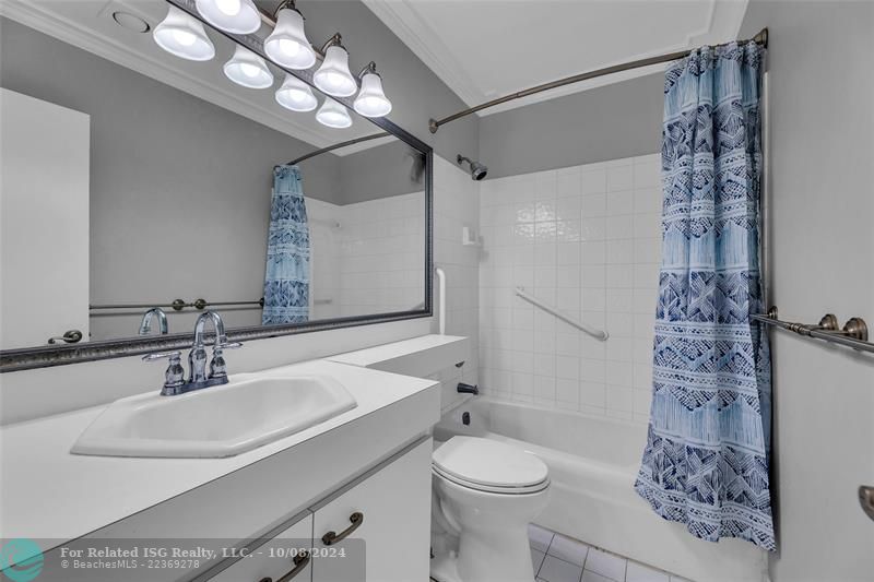 Full bath in with a bathtub.  View of hallway and into second bedroom.