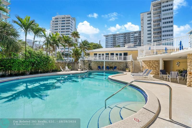 Pool area with lounge chairs and separate bathrooms with showers