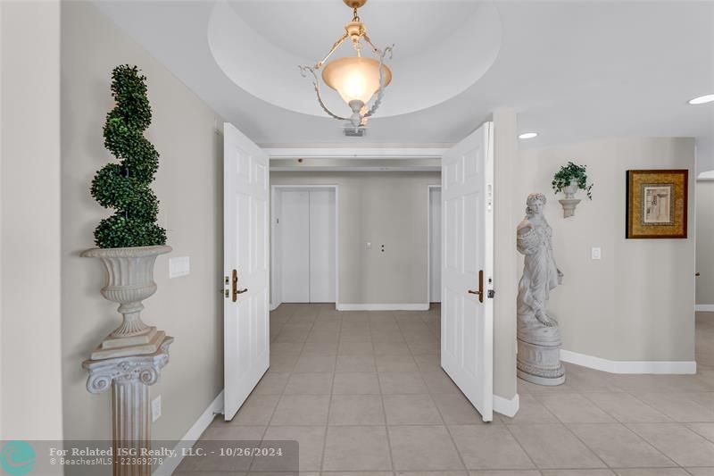 Elegant entry with coffered ceiling and double doors.