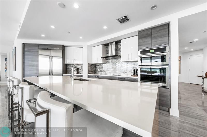 Gorgeous kitchen with Nolte cabinetry, lux backsplash, wet bar + wine fridge, tons of storage, large waterfall island & amazing views!