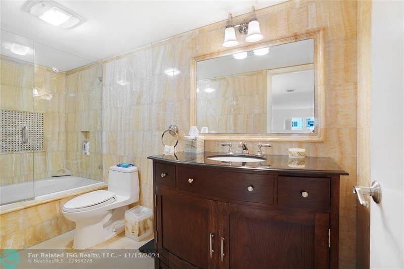 Beautiful marble walls are featured in this primary en suite bathroom.