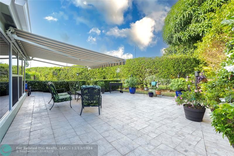 Gorgeous backyard with limestone pavers and retractable awning