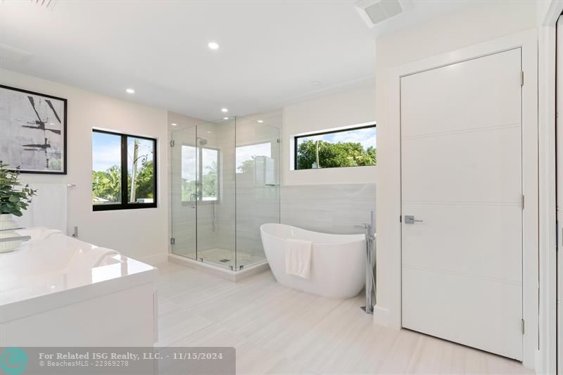 Primary bath with windows allowing for natural lighting.