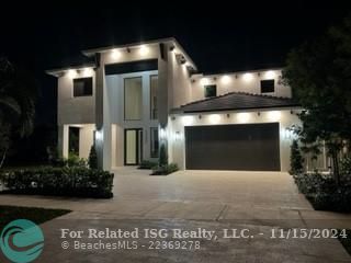 View at night with lavish lighting setting off this stunning home.