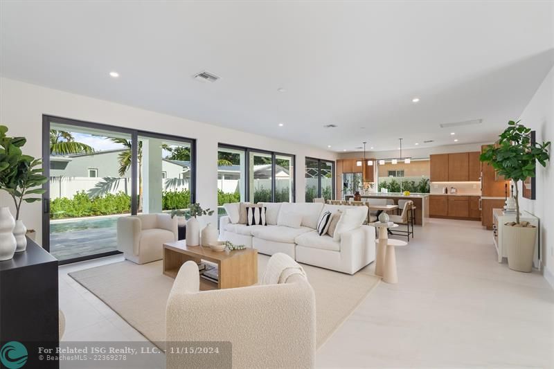 Open concept living area with glass sliders out to the patio and pool