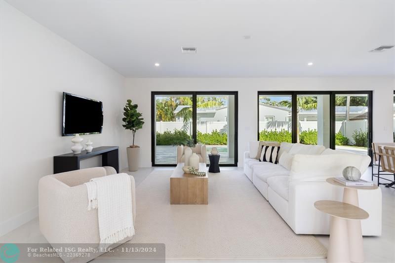 Open concept living area with glass sliders out to the patio and pool