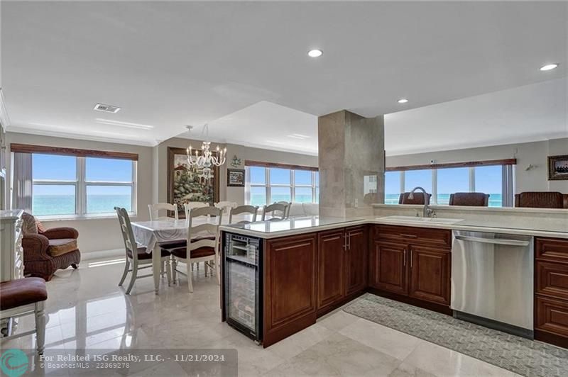 The kitchen, facing into the dining area. There is a wine refrigerator at the end of the kitchen counter.