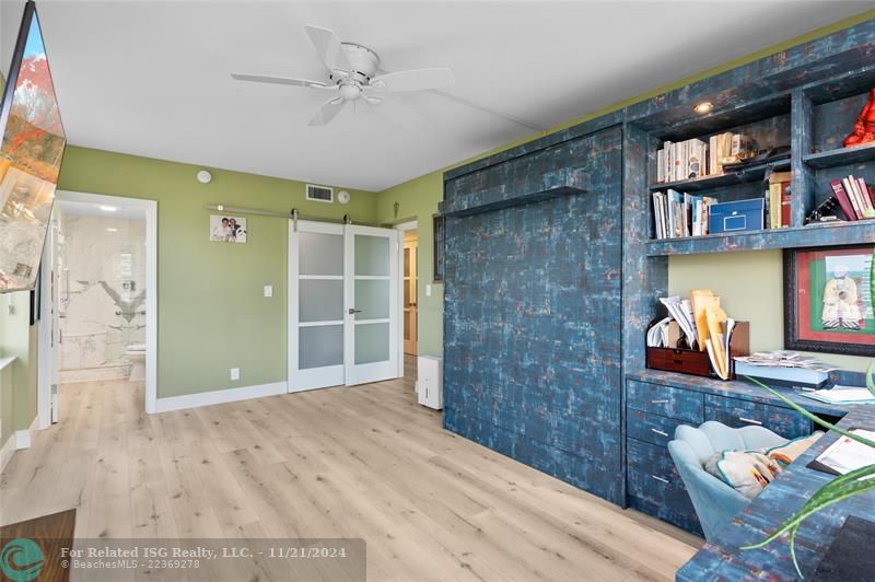 Primary bedroom set up as office with murphy bed.