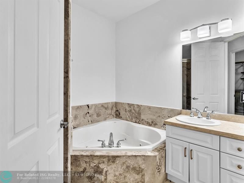 entrance to main bedroom with walk in on right and large bath on left