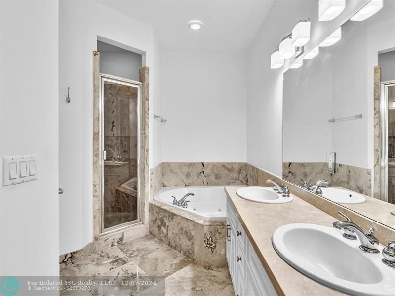 entrance to main bedroom with walk in on right and large bath on left