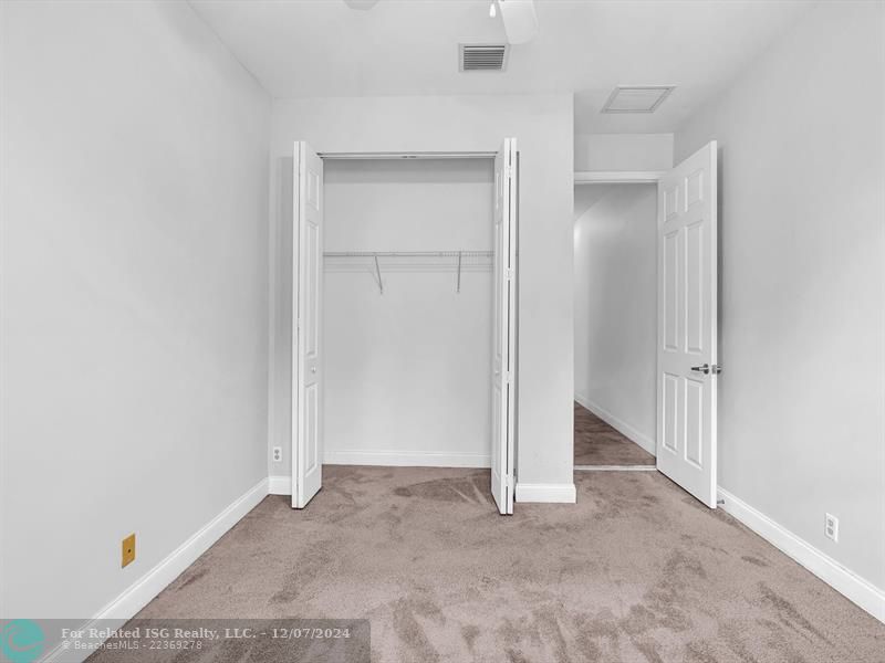 entrance to main bedroom with walk in on right and large bath on left