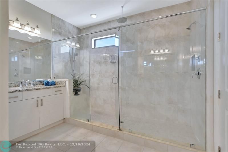 Extra large frameless shower with tile to the ceiling will wash away your worries.