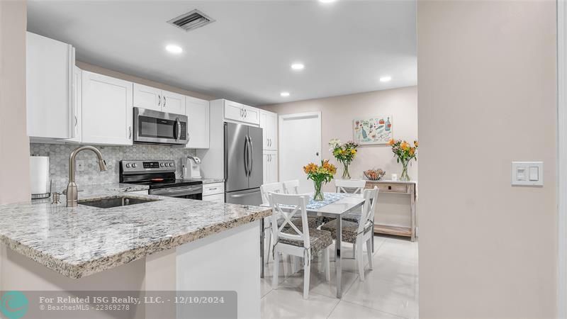 Granie snack counters and ample cabinets in this bright eat in kitchen