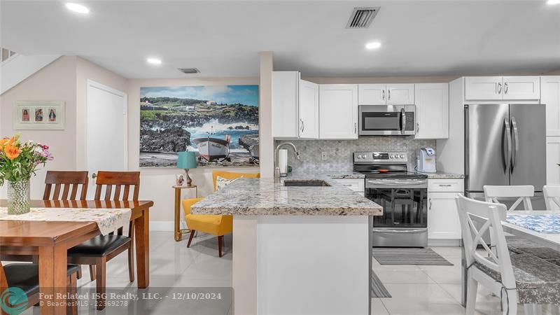 Granie snack counters and ample cabinets in this bright eat in kitchen