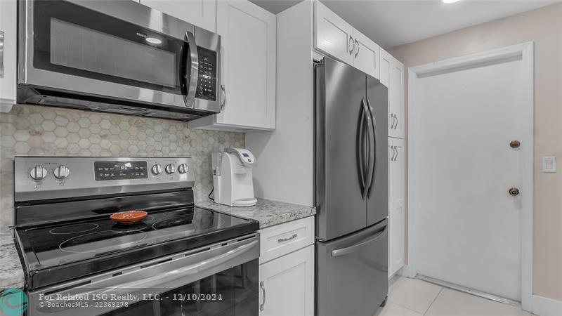 Granie snack counters and ample cabinets in this bright eat in kitchen