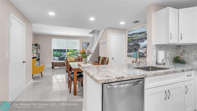 Granie snack counters and ample cabinets in this bright eat in kitchen