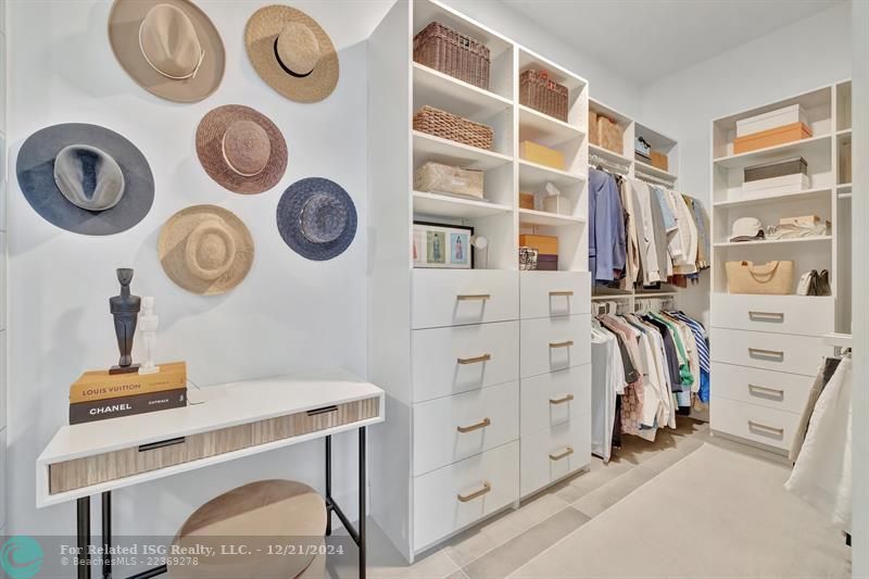 The primary bedroom has customized cabinetry in the walk-in closet for your convenience, offering ample storage and a sleek, organized aesthetic.