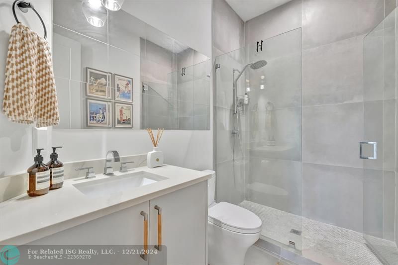 The 2nd bathroom also features a sleek glass-enclosed standing shower.