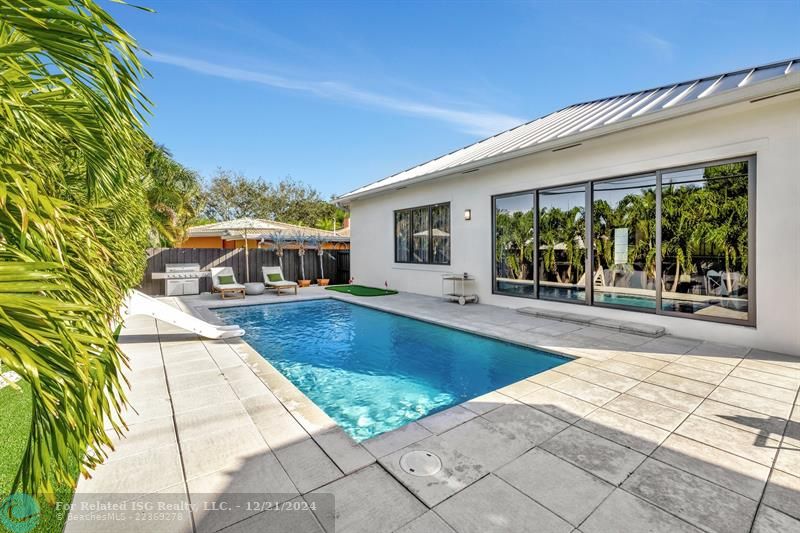 The lush tropical landscaping and fence provide a very private backyard.