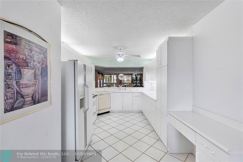 Large kitchen with lots of cabinet space and a desk.