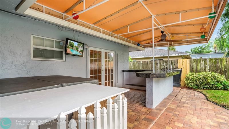 Outdoor oasis with covered bar and jacuzzi.